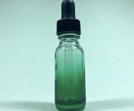 a small green glass dripper bottle