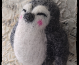 a small felted penguin